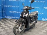 a black scooter that is parked in front of a blue backdrop