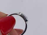a person holding a ring with a red heart on it