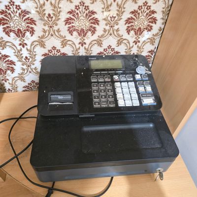 une caisse enregistreuse posée sur une table en bois