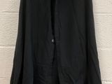 a black jacket hanging up against a white brick wall