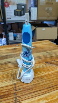 une brosse à dents branchée sur un chargeur posé sur une table