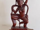 an image of a statue of a woman sitting on top of a wooden table