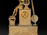 l'image d'une horloge en or sur laquelle est assise une femme