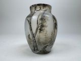 a black and white vase sitting on a white surface