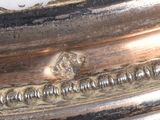 a close up of a silver plate with a bird on it