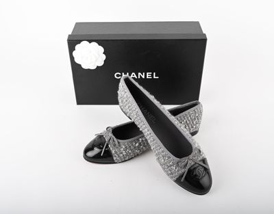black and white photo of a pair of chanel shoes in front of a black box