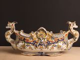 un grand saladier orné d'un motif de paon, posé sur une table