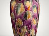 a purple vase that is sitting on a white surface