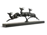 bronze sculpture of three running deers on a wooden base