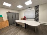 une photo d'une pièce avec une table et un réfrigérateur