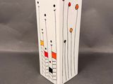 a white vase with red, yellow, and black flowers on it
