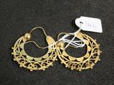 deux paires de boucles d'oreilles créoles en or posées sur une surface noire