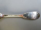 une cuillère en argent et une cuillère en argent posées sur une table