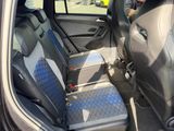 the back seats of a car with a blue checkered seat cover