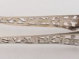 pair of silver plated spoons with writing on them on a white surface