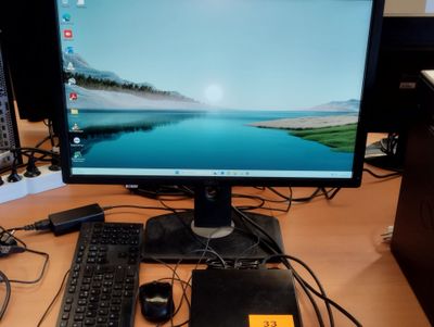 un écran d'ordinateur et un clavier posés sur un bureau