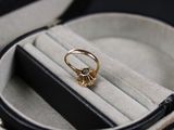a gold ring sitting in a black case on a table