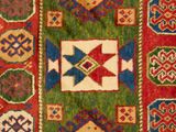 a close up of a red and green rug with geometric designs