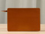 a brown leather wallet sitting on top of a wooden table
