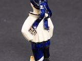 a small figurine of a woman with a blue scarf