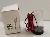 a box and a glass on a table with a red cord