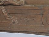 a statue of a woman reading a book on a bench