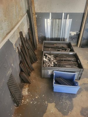 un tas de bois dans une pièce où se trouve une poubelle bleue