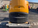 the back end of a yellow and black construction vehicle parked in a parking lot
