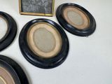 four black and gold picture frames sitting on top of a white table