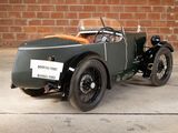 a vintage car that is parked in front of a brick wall