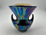 un vase en verre coloré avec une poignée noire sur fond blanc