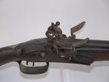 an old gun with a man riding on the back of it