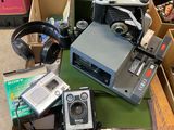 a pile of old cameras and other electronics on a table