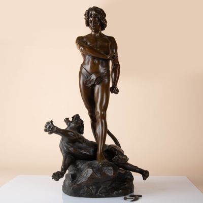bronze statue of a woman with a dog on a rock