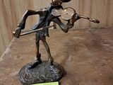 a statue of a man playing a violin on a table