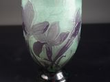 un verre vert orné de fleurs violettes