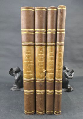 Quatre livres anciens sont empilés les uns sur les autres sur une table.