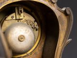a close up of a gold clock with a black background