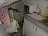 a small kitchen with a sink and a trash can in it