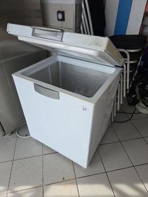 un congélateur coffre blanc posé à même le sol dans une pièce