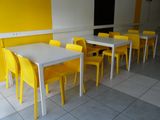yellow chairs and a white table in a yellow room