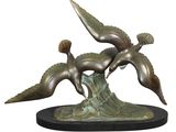 sculpture en bronze représentant deux oiseaux volant au-dessus d'une souche d'arbre