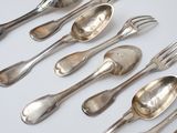 a lot of silver spoons and forks on the table
