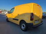 yellow van parked in a parking lot with other cars in the background