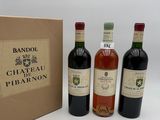 trois bouteilles de vin sont posées à côté d'un carton sur une surface blanche