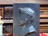 une image représentant une statue d'un homme coiffé d'une couronne, à côté d'un bocal de cacahuètes
