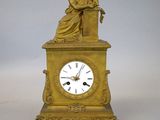 une horloge en or surmontée d'une statue