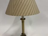 une lampe de table ancienne en laiton, surmontée d'un abat-jour rayé