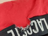 the back of a red jacket with a black and white label on it