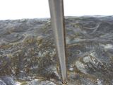 a close up of a metal object with a knife sticking out of it
